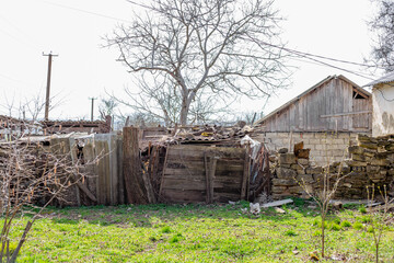 Scene of desolation with crumbling building and overgrown foliage in rural area. Old house and...