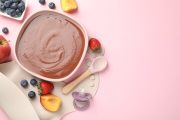 Baby food. Tasty puree in bowl, spoon and ingredients on pink table, flat lay. Space for text