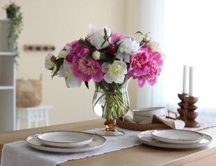 Beautiful table setting with bouquet of peonies in dining room, closeup