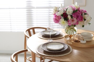 Beautiful table setting with bouquet of peonies in dining room. Space for text