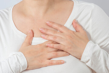 Female hands massage a painful chest with heart pain. Women's health, middle age.