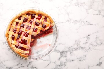 Tasty strawberry pie in baking dish on white marble table, top view. Space for text