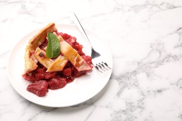 Piece of tasty strawberry pie on white marble table, closeup. Space for text