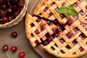 Tasty cut cherry pie and berries on wooden table, flat lay