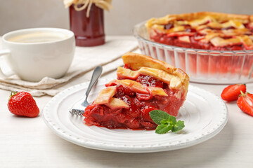 Piece of tasty strawberry pie and berries on white wooden table, closeup