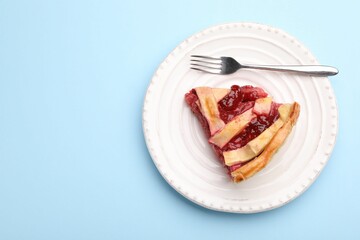 Piece of tasty strawberry pie on light blue background, top view. Space for text