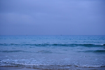 calm ocean waves on a cloudy beach in evening in Sanya, Hainan, China