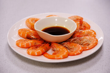 plate of freshly cooked shrimp with dipping sauce