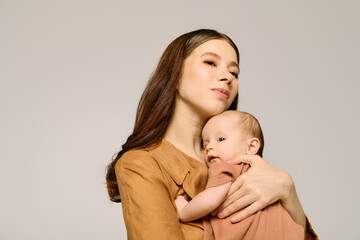 Beautiful young mother lovingly embracing her adorable child in a modern studio setting