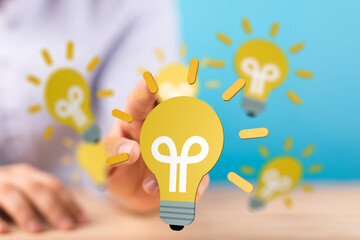 Boost your creativity! Stock photo of hand interacting with glowing lightbulb icons, symbolizing...