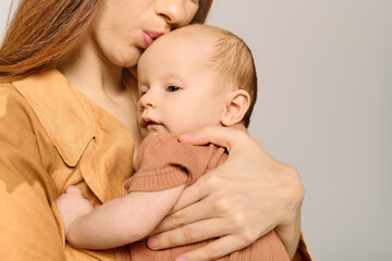 Joyful moments of a beautiful young mother embracing her little child in a warm, intimate setting