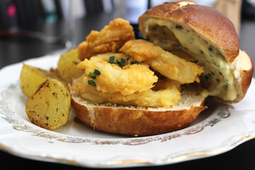 Delicious burger revisited with calamari with tartar sauce and baked potatoes with herbs and olive oil.