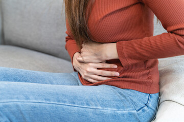 asian young woman intolerance hand in stomach ache, suffer from food poisoning, abdominal pain and...