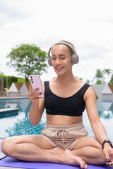 Genderfluid gay man with mustache and lipstick relaxing poolside while wearing a bikini-style top....