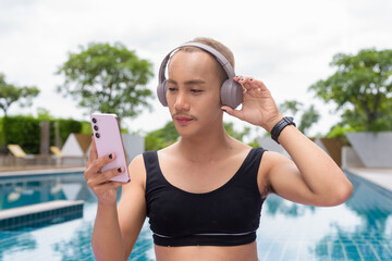 Genderfluid gay man with mustache and lipstick relaxing poolside while wearing a bikini-style top....