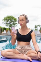 Genderfluid gay man with mustache and lipstick relaxing poolside while wearing a bikini-style top....