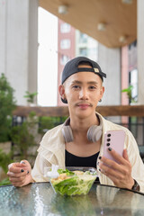 Non binary gay man eating salad