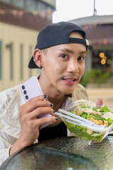 Non binary gay man eating salad