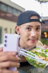 Non binary gay man eating salad