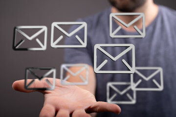 A man's hand displays multiple email icons, symbolizing email management and communication.