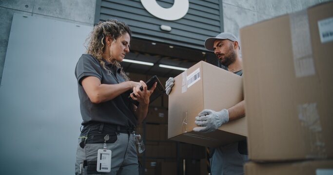 Diverse Employees Carrying Cardboard Boxes to Logistics Warehouse. Female Coordinator Scanning Parcels with Barcode Scanner, Using Digital Tablet. Online Orders, Delivery and E-Commerce Goods. - Powered by Adobe