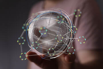 Person holding a futuristic holographic globe, representing global network, data, and connectivity.