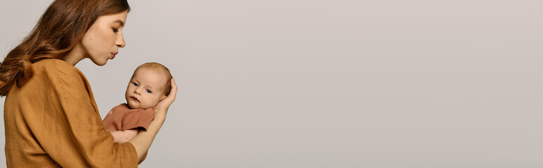 Young mother lovingly gazing at her infant during a quiet moment together in soft pastel setting