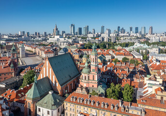Dachy warszawskiej Starówki z nowoczesnym centrum miasta w tle.