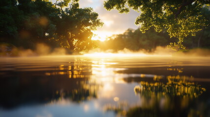 Sunrise over tranquil water with mist rising and lush trees reflecting in the serene landscape