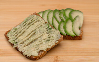 Avocado spread on a sandwich on a chopping board