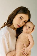 Young mother embraces her infant child in a tender moment of connection and love indoors