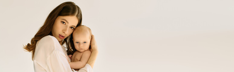 Beautiful young mother holds her little child lovingly in a calm and serene setting