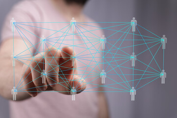A hand interacts with a digital network showing interconnected people.  Represents global...