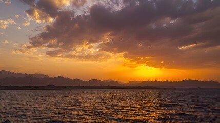 Fototapeta premium Dramatic Red Sea Sunset with Fiery Crimson Sky Reflecting on Turquoise Waves, Egypt Coastline Silhouette Under Volcanic Cloud Formations, Empty Horizon Composition