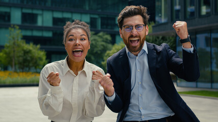 Two happy multiracial business colleagues partners winners African American woman businesswoman...