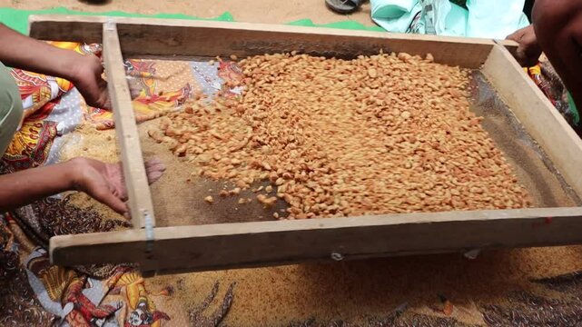 Traditional Indian cook sifting freshly prepared churma through a large sieve (chalni), part of the authentic Rajasthani sweet-making process