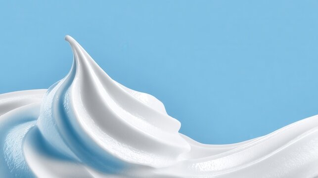 Swirls of creamy white topping cascade in graceful waves contrasting with a cool blue backdrop evokes desserts and airy lightness
