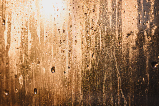 Condensation on dirty window, morning sunlight