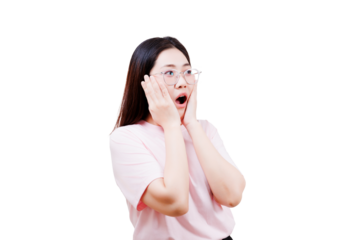 A young woman with long dark hair and glasses, wearing a light pink shirt, expresses surprise with her mouth open and hands on her cheeks.