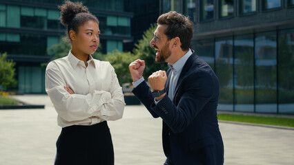 Two multiracial business colleagues different emotions in city African American woman businesswoman...