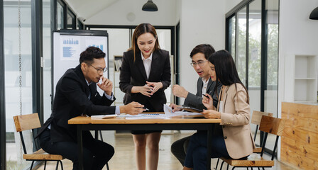 Business Team Meeting: A diverse team of business professionals collaborates around a table during...