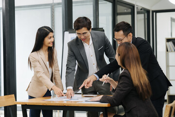 Focused Minds in Synergy: A dynamic team of business professionals collaboratively strategize around a table. Their intense focus and shared dedication is captured, showcasing the essence of teamwork.