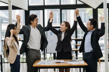 Triumphant Team in a Modern Office: A dynamic group of colleagues celebrates a shared success. With...
