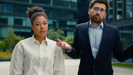 Two sad upset multiethnic coworkers business colleagues managers Caucasian man businessman male guy...