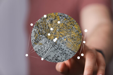 Person interacts with a digital globe, showcasing city networks and global connectivity.