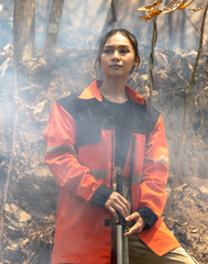 Vertical courage Asian female local fire fighter fighting with forest fire 