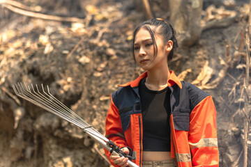 Courage Asian female local fire fighter fighting with forest fire 