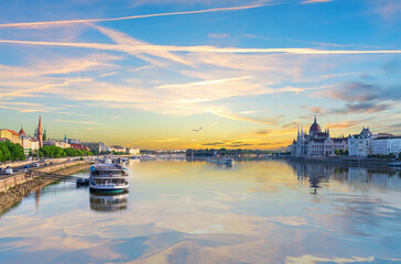 Sunset over Danube River with Parliament building and cruise ships in Budapest, Hungary