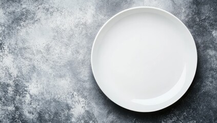Empty white plate on gray mottled surface