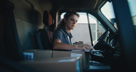Female Delivery Truck Driver in Car Using Tablet Computer, Filling Out Papers, Delivering Cardboard...
